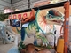 Les enfants montent sur le dinosaure de parc à thème pour l'équipement de divertissement